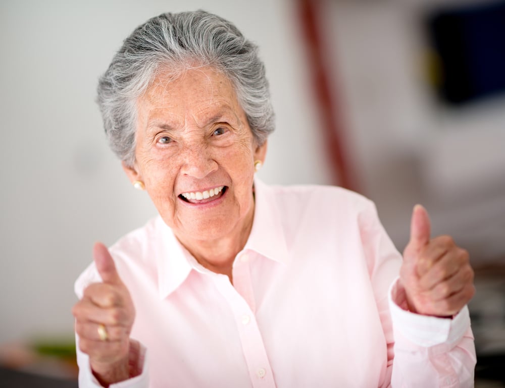Portrait of a happy senior woman with thumbs up